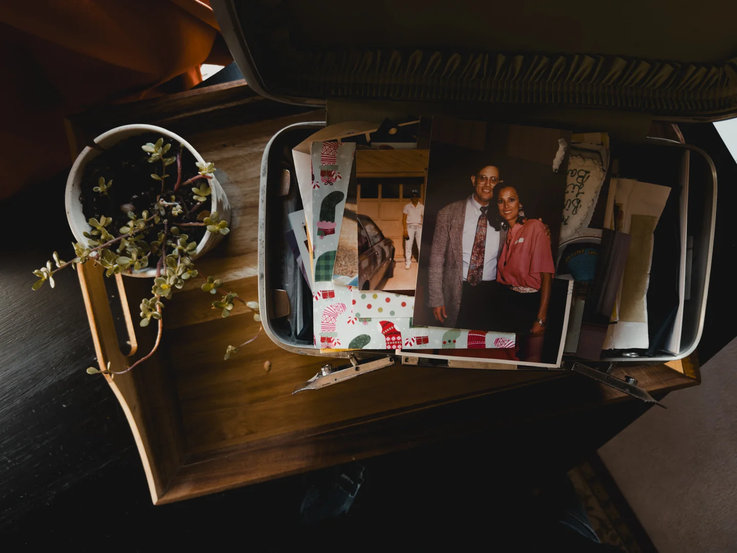 The open keepsake box filled with family photographs, with a portrait of Bart’s parents resting on top.