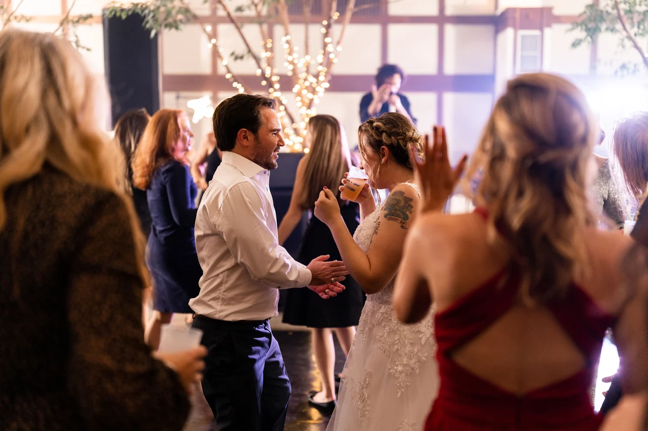 Bride and groom dance with guests around them.